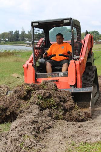 Robert Seeber, co-owner of SF Aquatics, operates a Kobta to move weeds from a beach area in Sebring. After removing the weeds, he leveled the sand to create a beach for the homeowner.
