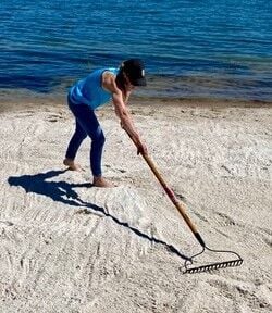 Valerie Cobb rakes the sand at a recent beach project she helped SF Aquatics do.